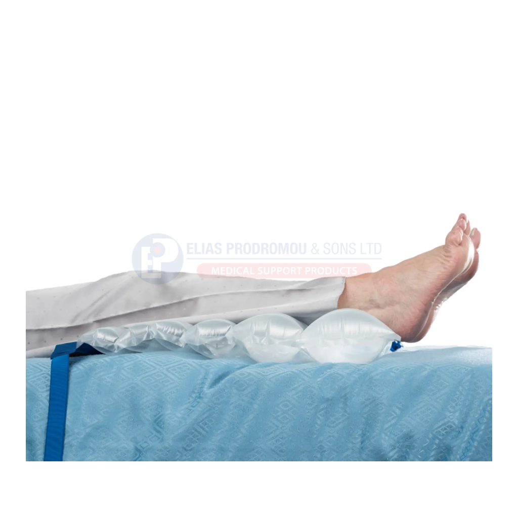 Lower legs supported on a Standard Wedge with heels beyond the edge. Bed and linen shown for context are not included.